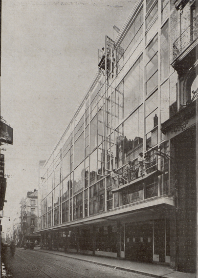 Photo du magasin Decré, montrant la longueur du bâtiment et la surface vitrée. Des personnes dans une nacelle sont en train de nettoyer.