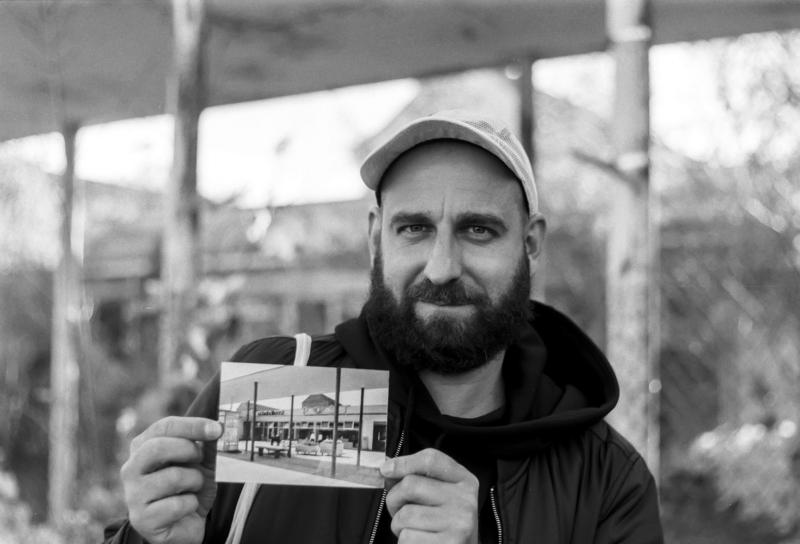 Portrait de l’architecte avec une carte postale d'Eisenhüttenstadt datant des années 1960.